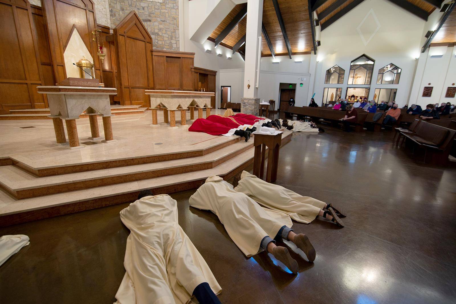 Clergy and servers prostrate themselves before the altar and crucifix at the start of the Good Friday liturgy April 2 at St. Pius X Church in Greensboro. (Photo provided by MaryAnn Luedtke)