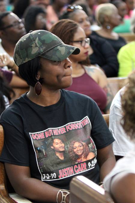 Members of the Carr family attended the prayer service, wearing T-shirts with Justin Carr's photo and the phrase 'gone but never forgotten'