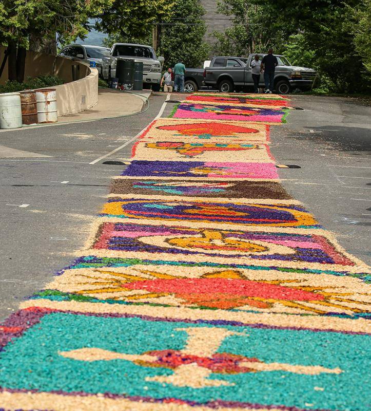 A sawdust carpet made up of many individual sections is fashioned along the procession route.
