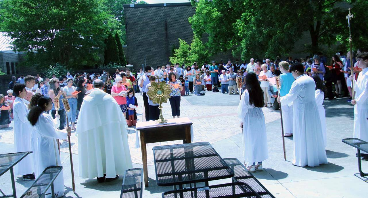 Father John Starczewski, pastor at St. John Neumann Catholic Church in Charlotte, led the congregation in an outdoor procession to three altar locations on campus. The bi-lingual service included readings, prayers and adoration. (Provided photo)