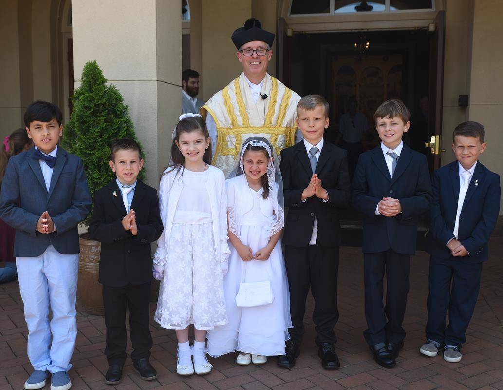 CHARLOTTE —Pictured with their pastor, Father Timothy Reid, are Clare Cascio, Jacob Cooper, Luke Doll, Emilia Ferrante, Benedict Grabowski, Gabriel Guerra and Dominic Russo. (Photo provided by Markus Kuncoro)