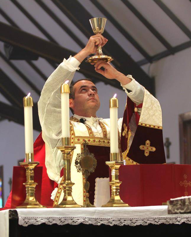 Additional attendees took advantage of the pleasant weather to gather on the church grounds for the Mass, receiving Communion from Father Becker at the front door.