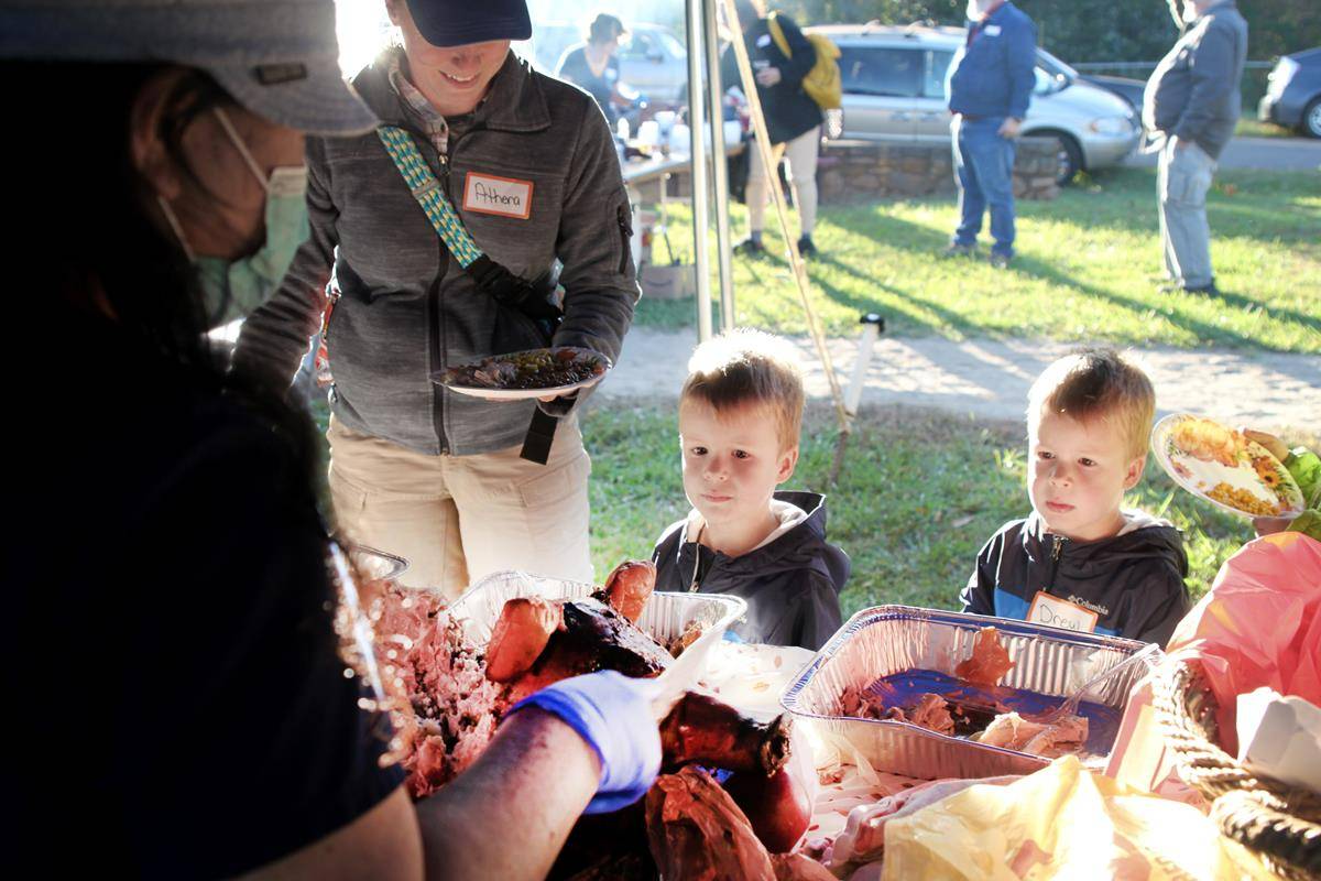 Young parishioners warily eye the roast pig – apple in his mouth – featured on the buffet table. 