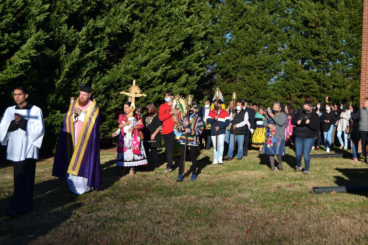 Parishioners of Holy Cross Church follow the cross and an image of Our Lady of Guadalupe in a procession led by Father Noah Carter, pastor, for the feast day. (Photo by Paul Doizé)