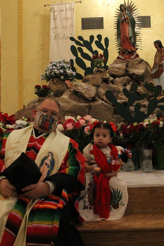 Father Roberts is pictured with one of his younger parishioners at the celebration. Both are wearing traditional clothing in honor of Mexican heritage. (Photo by SueAnn Howell)