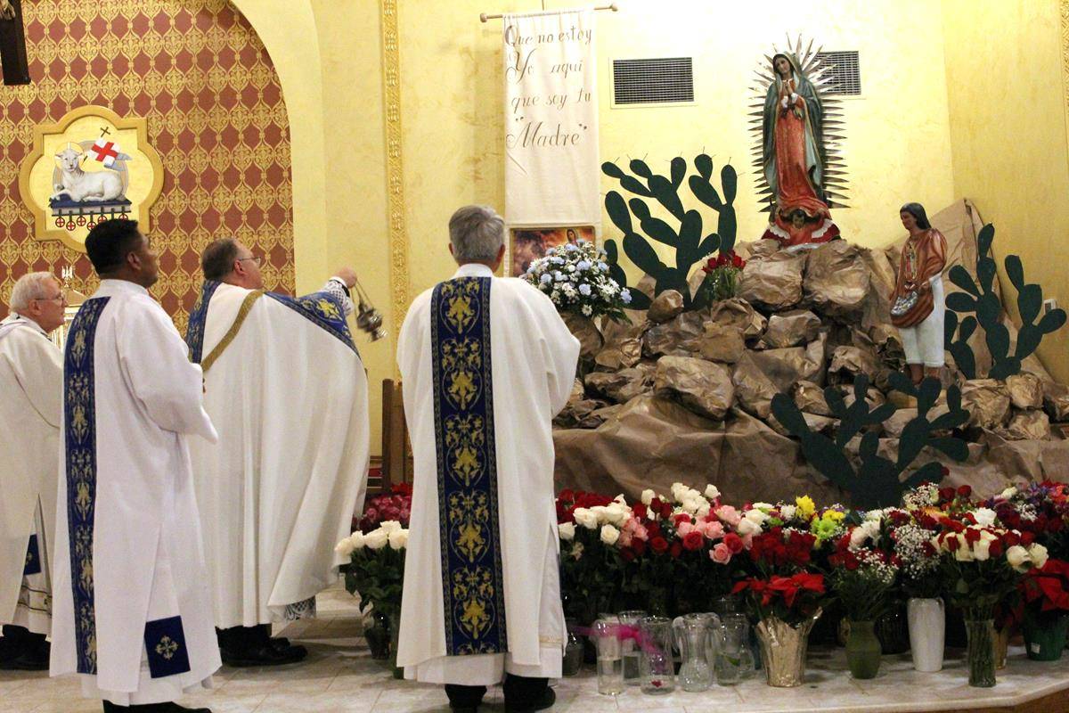 Father Roberts incenses an image of Our Lady of Guadalupe Dec. 11. (Photo by SueAnn Howell)