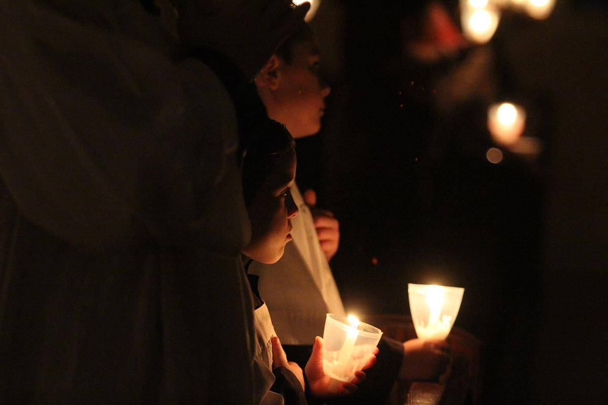 St. Ann Church altar servers hold candles as they pray during the Mass. (Photo by SueAnn Howell) 