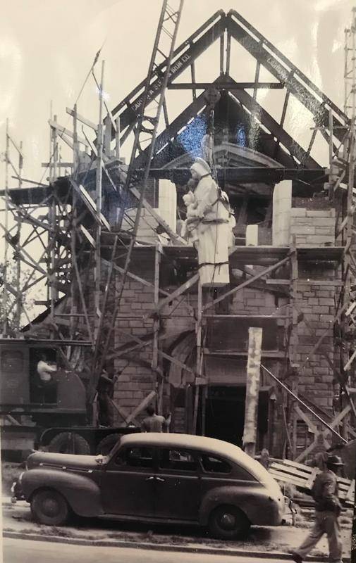 The construction crew elevates the stone statue of Our Lady and her infant Son for the church’s main entrance on Market Street.
