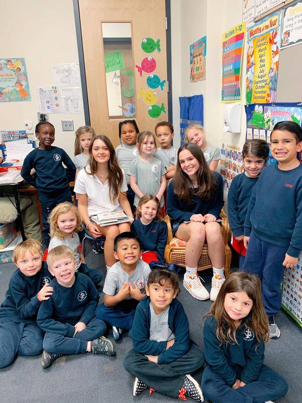 Bishop McGuinness freshmen Francesca Daccio and Lauren Showers read to young students at their alma mater, Immaculate Heart of Mary School in High Point.