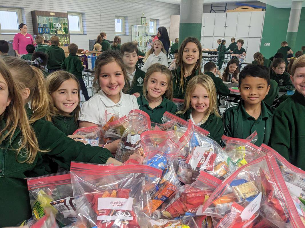 On Tuesday, St. Patrick School first and third graders listened to a guest speaker from Charlotte Rescue Mission. Then they made snack bags and notes for CRM.