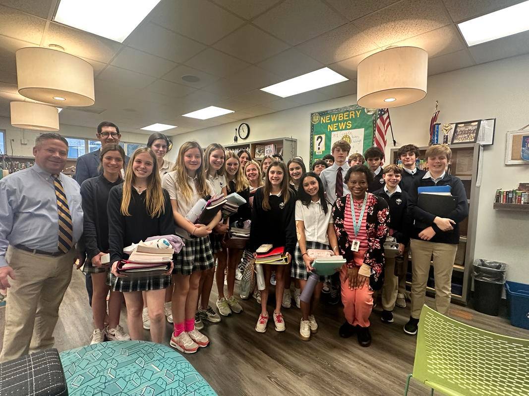 Greensboro’s St. Pius X eighth graders pose in the library with Superintendent Greg Monroe, Principal Chris Kloesz, and Instructional Assistant Kendra Winston.