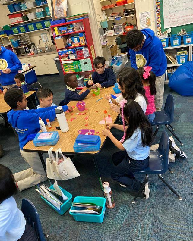 Our Lady of the Assumption School prayer partners in 7th and first grades work together on an art project to bring some cheer to the local community.