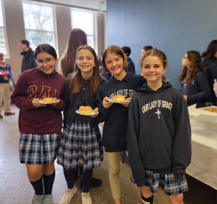 OLG (Students at Our Lady of Grace School hand out treats after Mass to start Catholic Schools Week.)