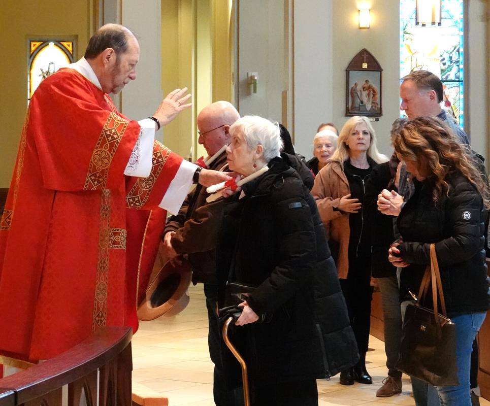 Father Melchesideck Yumo and Deacon Rich McCarron imparted the traditional throat blessing for the Feast Day of St. Blaise at the 9 a.m. Mass at St. Mark Church in Huntersville.