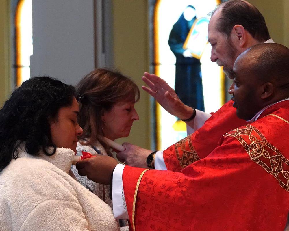Father Melchesideck Yumo and Deacon Rich McCarron imparted the traditional throat blessing for the Feast Day of St. Blaise at the 9 a.m. Mass at St. Mark Church in Huntersville.