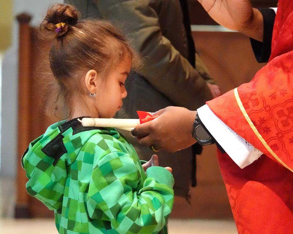 Father Melchesideck Yumo and Deacon Rich McCarron imparted the traditional throat blessing for the Feast Day of St. Blaise at the 9 a.m. Mass at St. Mark Church in Huntersville.