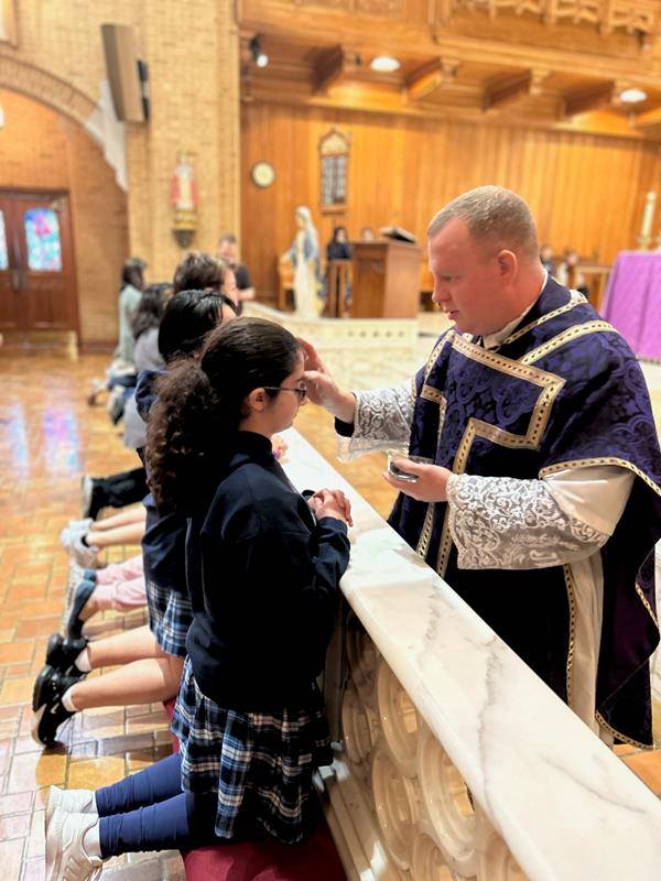 Students at Our Lady of Grace School in Greensboro receive ashes in a Mass celebrated by Father Casey Coleman. (Photos by Annie Ferguson.) 