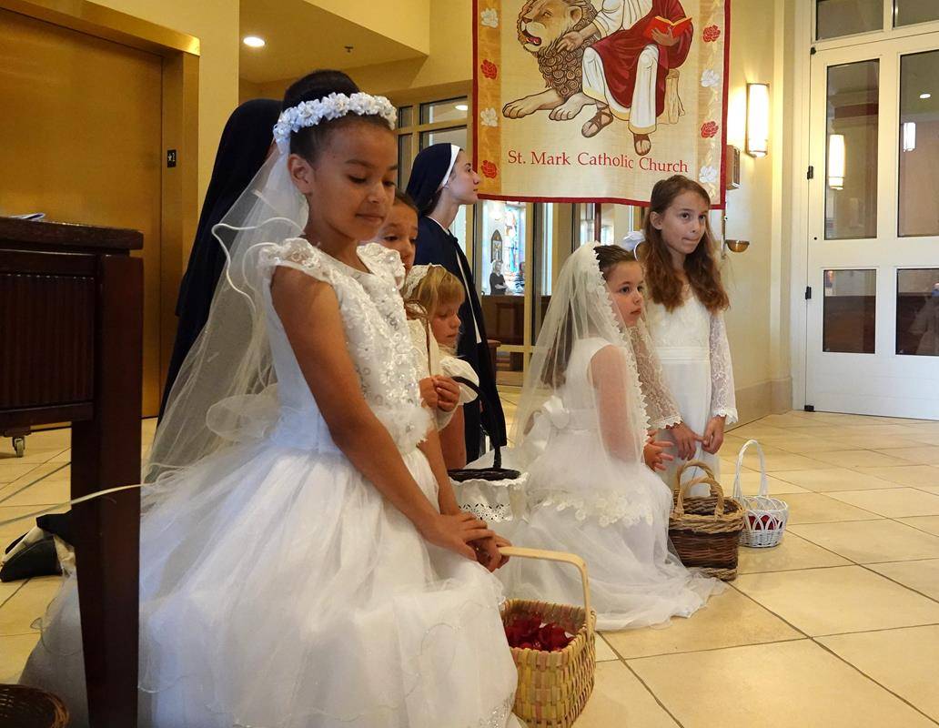 Sisters from the Daughters of the Virgin Mother organized the flower girls with rose petals and Diocese seminarians assisted and served at both Masses and Processions. (Photos by Amy Burger)