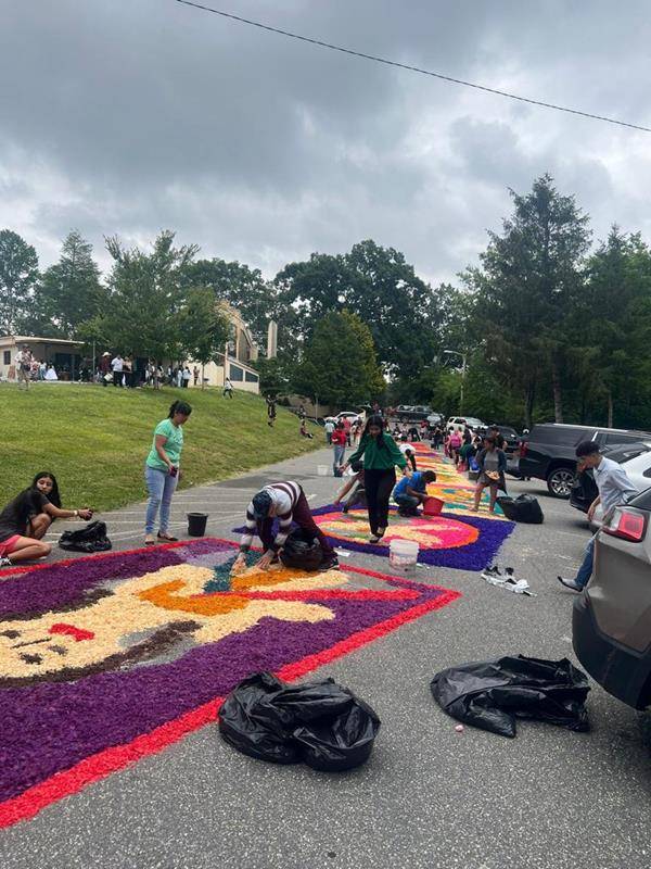 The faithful made colorful flower carpets to receive the Eucharist Procession at St Francis of Assisi in Franklin. They started working early in the morning.