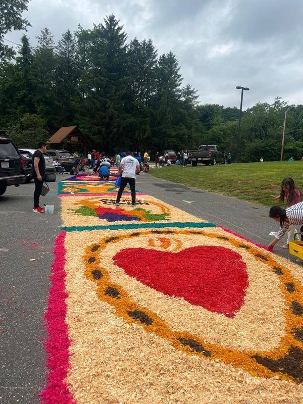 The faithful made colorful flower carpets to receive the Eucharist Procession at St Francis of Assisi in Franklin. They started working early in the morning.