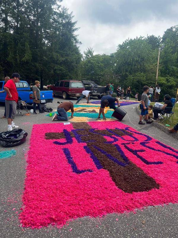 The faithful made colorful flower carpets to receive the Eucharist Procession at St Francis of Assisi in Franklin. They started working early in the morning.