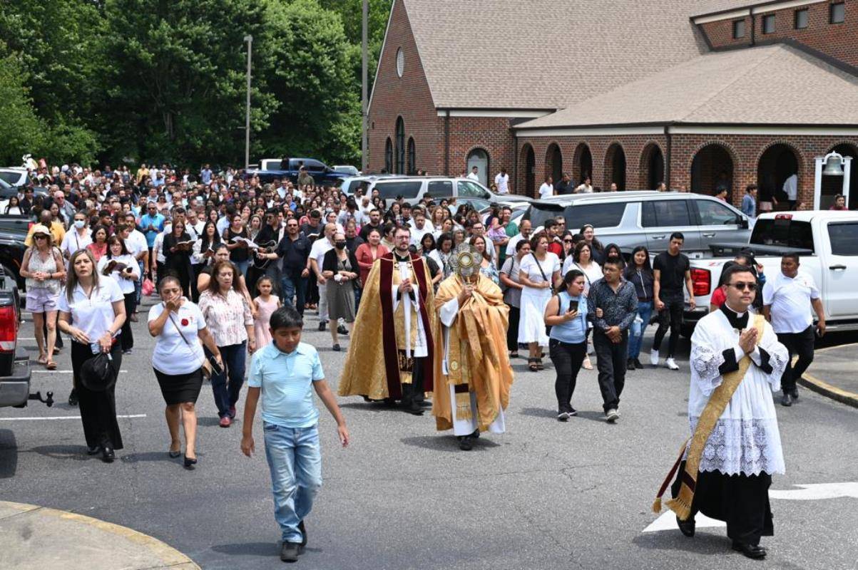 Fr. José Juya, parish vicar, lead the Eucharist Processional with Fr. Lucas Rossi, pastor at St. Michael Church in Gastonia. A crowd of parishioners follow them through the facilities until gather at Mass.