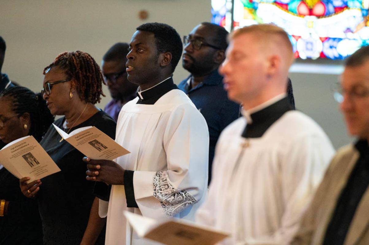 Chinonso Nnebe-Agumadu and his family and friends chant evening prayer during the Holy Hour at St. Patrick Cathedral Thursday.