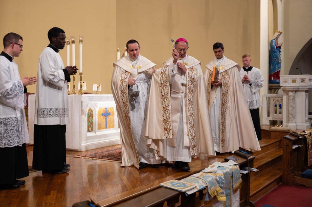 Bishop Peter Jugis blesses the vestments of Chinonso Nnebe-Agumadu, who is being ordained to the priesthood Saturday.