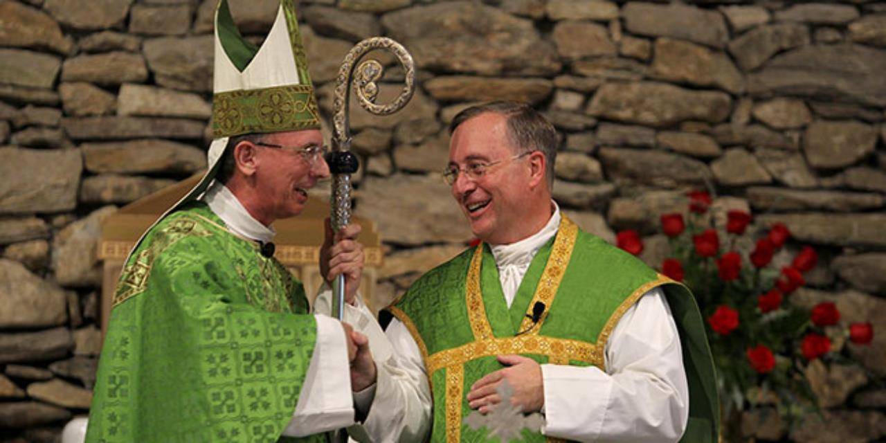 Bishop Peter Jugis congratulates Father Christian Cook after installing him as pastor of Immaculate Conception Church in Hendersonville.