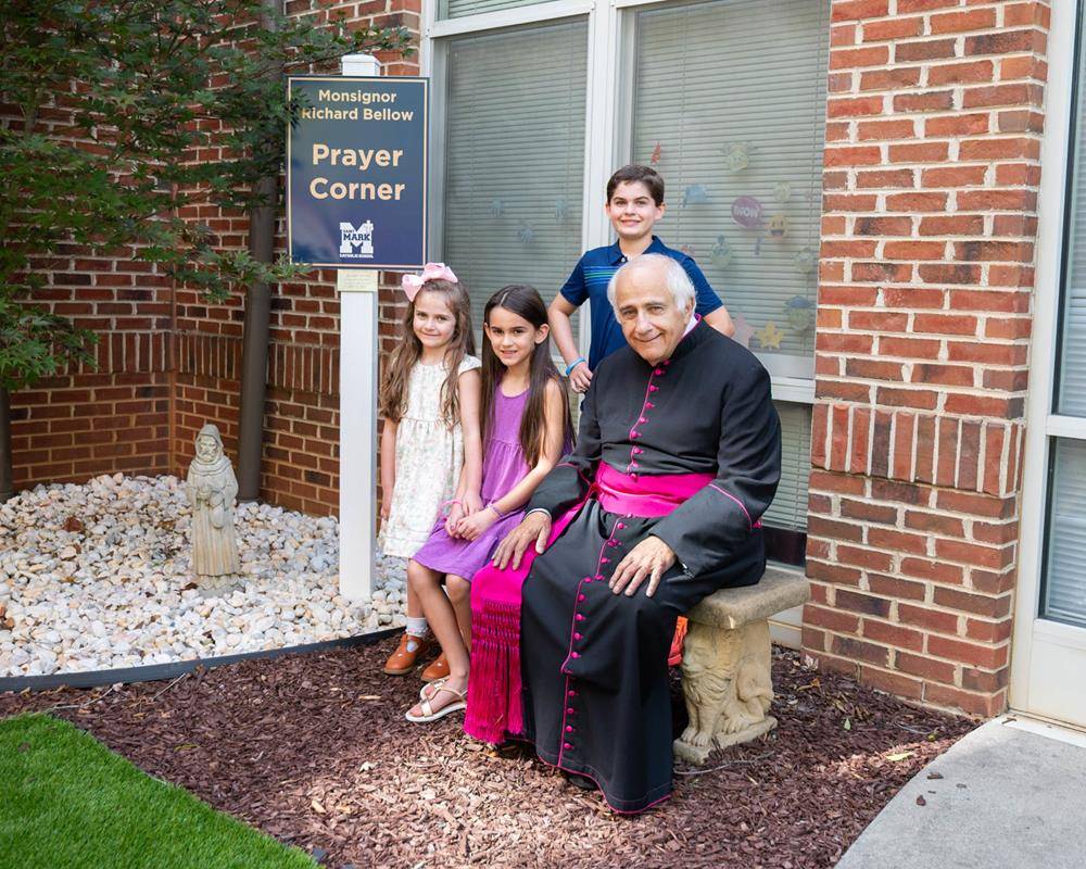 Msgr. Bellow pictured in the prayer garden named in his honor