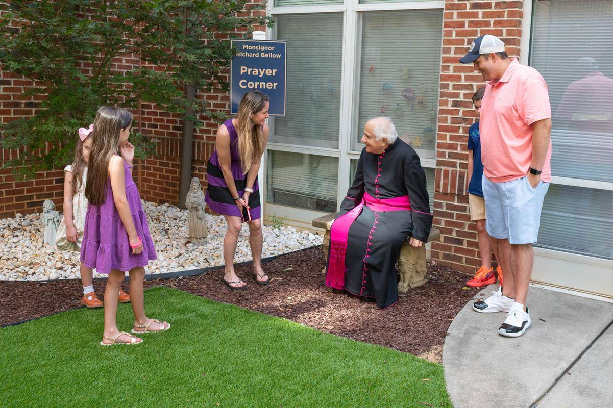 Msgr. Bellow pictured in the prayer garden named in his honor