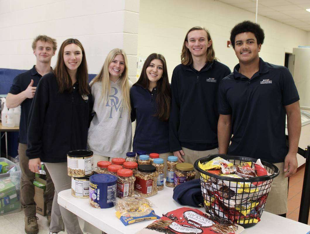 Students at Bishop McGuinness High School participated in a school-wide day of service Monday, which included packing trail mix for organizations that serve the hungry