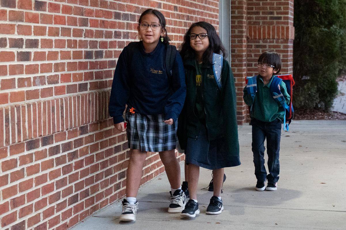 Dr. Gregory Monroe, Superintendent of Catholic Schools, greets students at St. Mark School in Huntersville for the start of Catholic Schools Week. 
