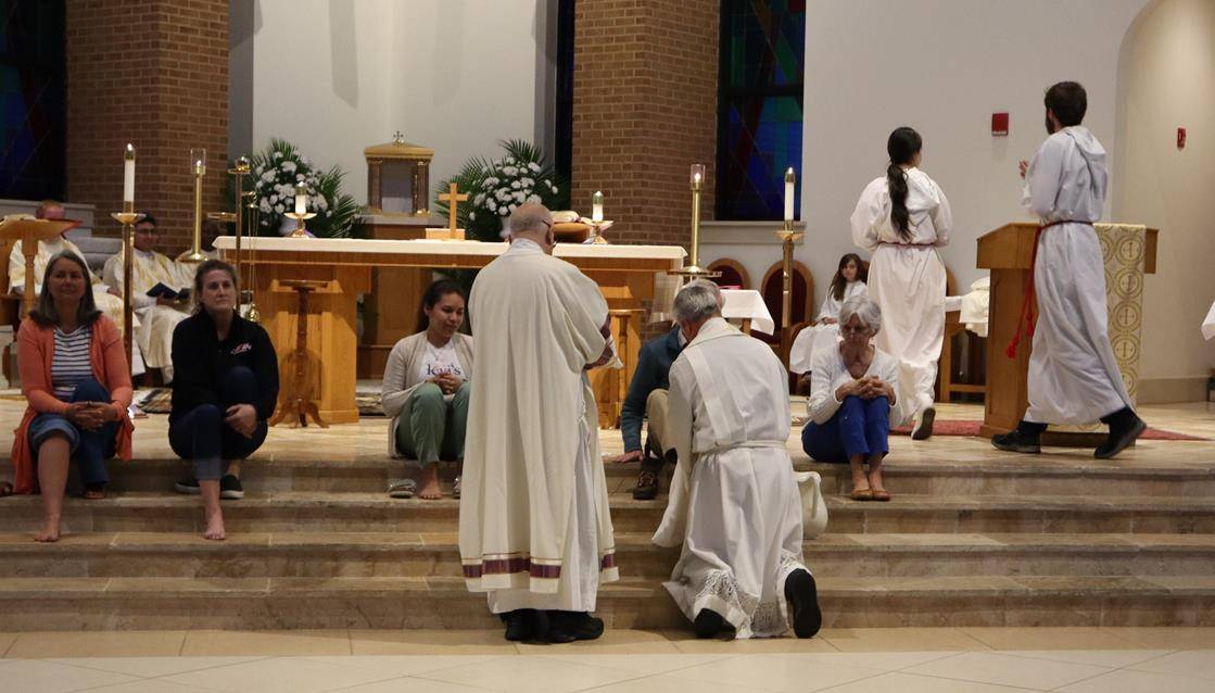 Father Mark Lawlor washes the feet of his parishioners at St. Therese Church in Mooresville.