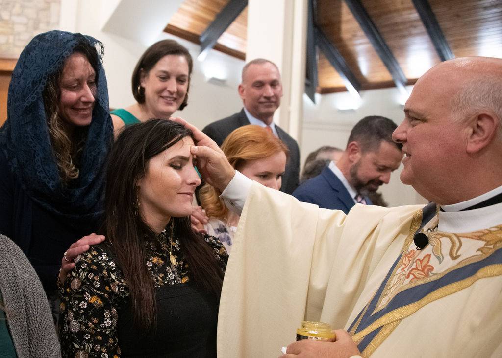 Monsignor Anthony Marcaccio confirms new Catholics at the Easter Vigil Mass March 30.