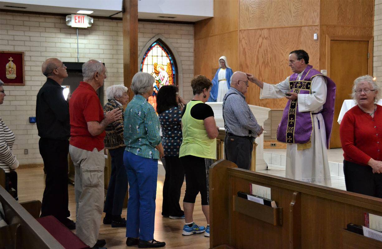 Father Fitz imposing ashes on foreheads of the congregation at Our Lady of Annunciation Parish in Albemarle.
