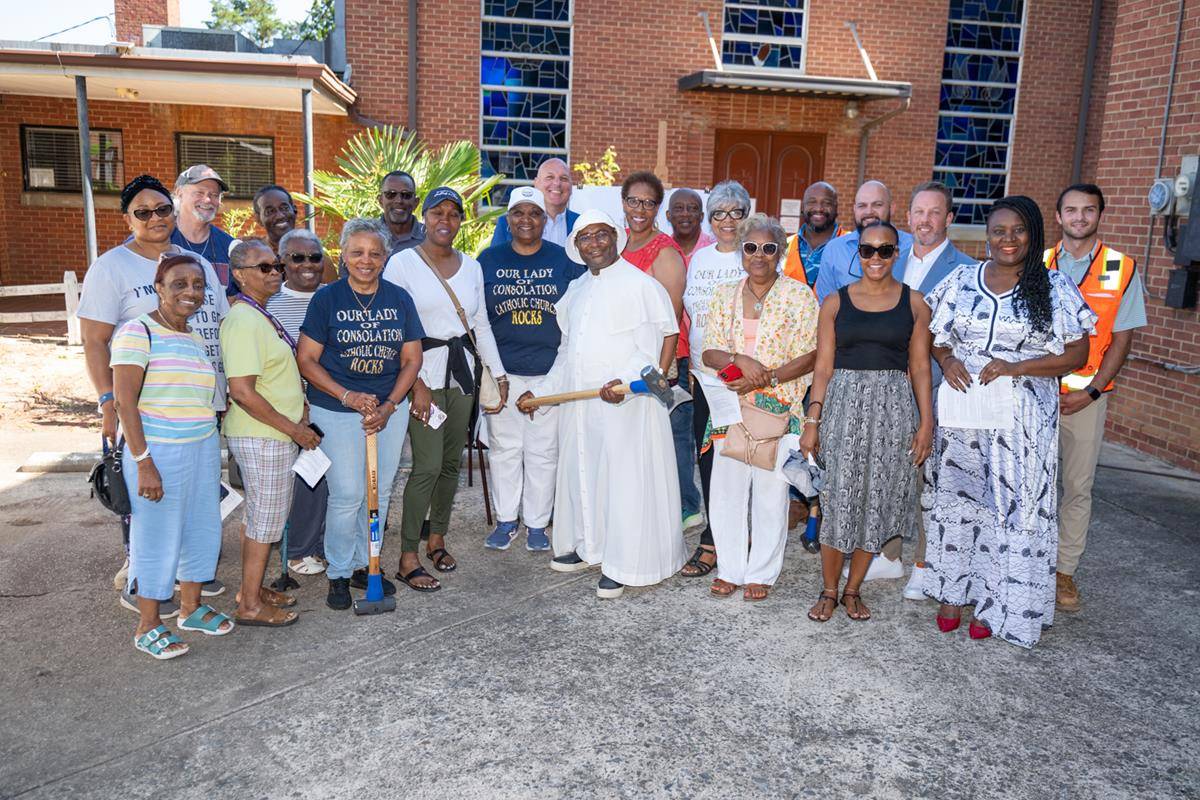 Father Basile Sede, Our Lady of Consolation pastor, along with others from the church, donned a construction hard hat and wielded a ceremonial sledgehammer for photos and exclaimed, “Let’s build!”