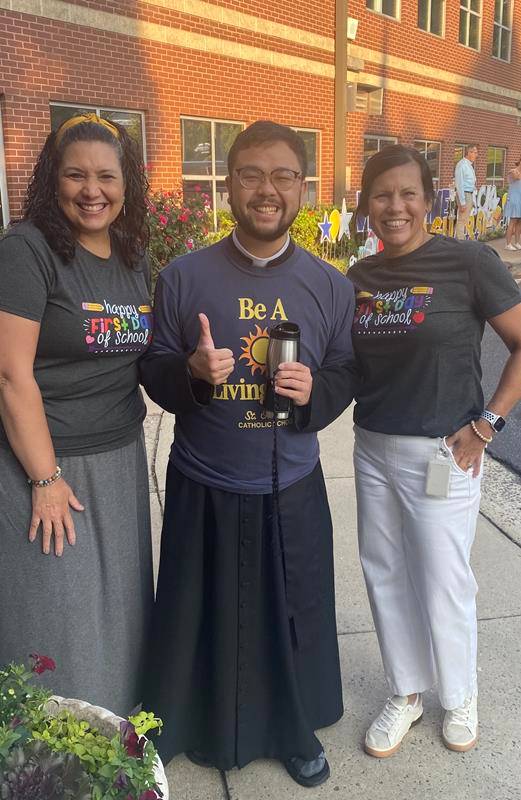 Staff and Father Kevin Tran welcomes students to St. Gabriel School in Charlotte. 