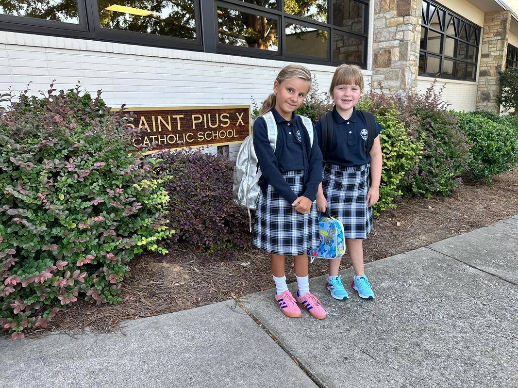 Students smile as they arrive at St. Pius X School in Greensboro for the first day of school.