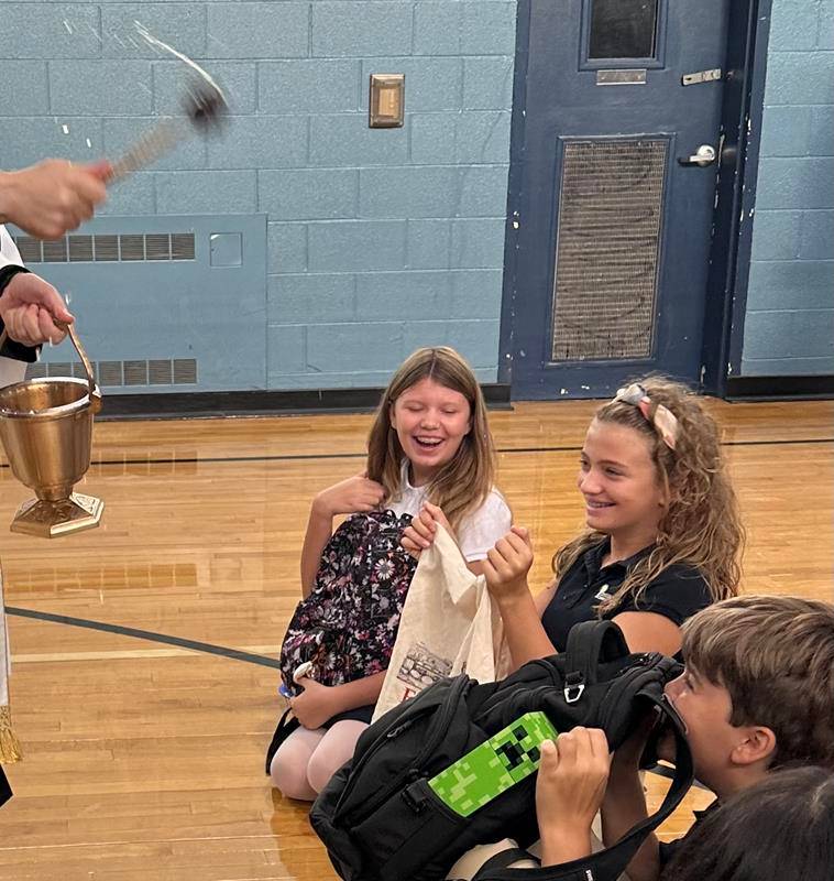 The annual “Blessing of the Backpacks” marked the start of the first day of school at Immaculata Catholic School with Father Andres Gutierrez dispersing holy water in the gym during morning assembly Aug. 19. 