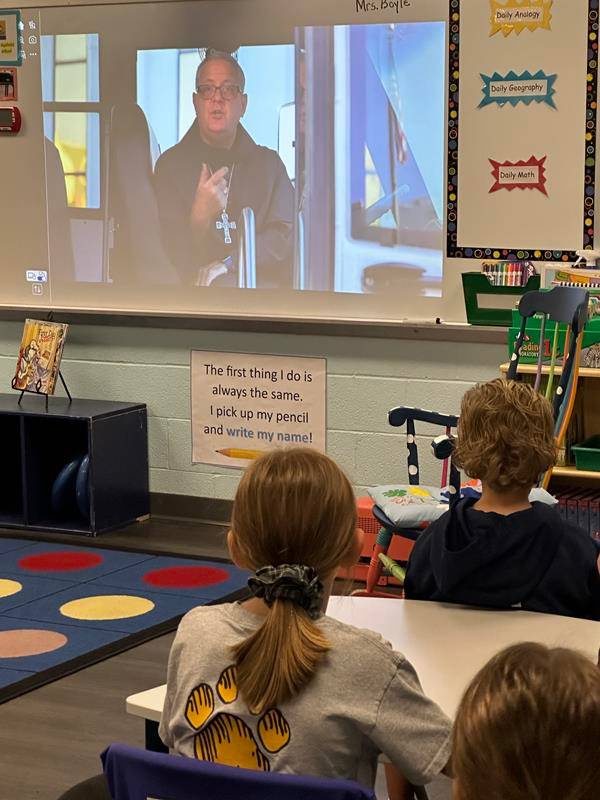 Students at St. Gabriel School in Charlotte watch a message from Bishop Martin on the first day of school. 