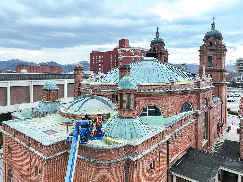 Workers on a cherry picker survey the roof of the historic basilica.