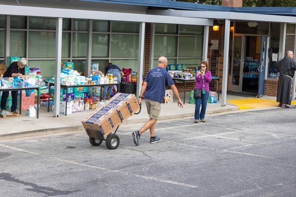 Aid is quickly unloaded and then sorted and distributed to awaiting cars. (Gabriel Swinney)