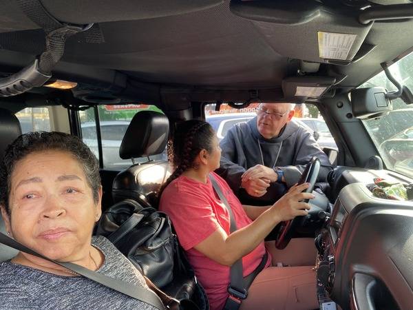 Bishop Martin talks with a family that drove in to Immaculata to pick up necessities.