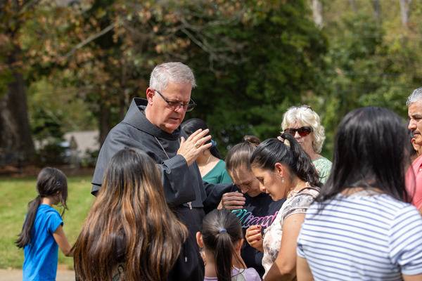 The bishop joined in prayer and offered spiritual consolation to those who had gathered on the church lawn. (Gabriel Swinney)