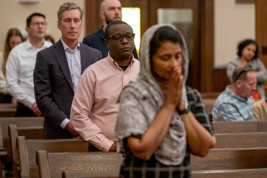 People pray during Mass at St. Peter Church in Charlotte. (Photo by Troy Hull)
