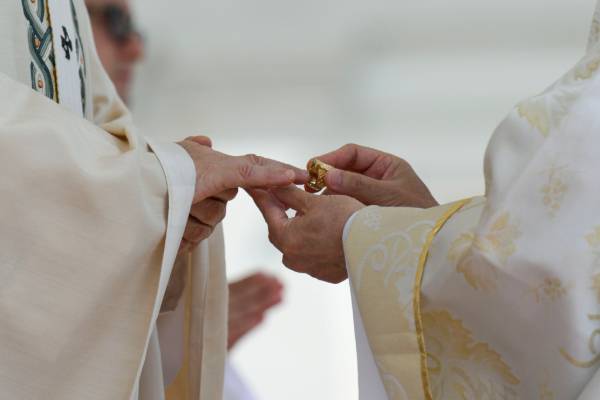 Pope Leo XIV, left, receives the fisherman's ring, symbolizing his role as successor to St. Peter, from Filipino Cardinal Luis Antonio Tagle, right, during the pope's installation Mass in St. Peter's Square May 18. (CNS/Vatican Media)