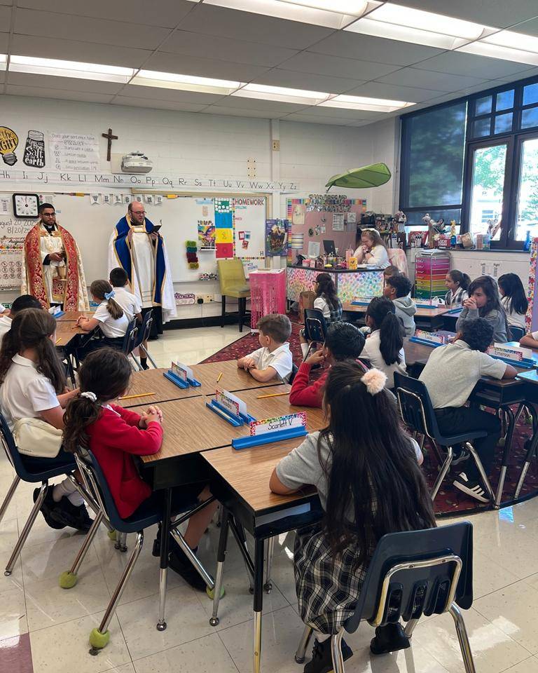 Father Cory Catron and Father José Palma bless the classrooms at Our Lady of Mercy School in Winston-Salem. 